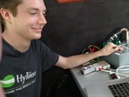 <p><strong>Hyliion engineer Morgan Culbertson, who wrote the control program, here controls the tandem with sliding toggles. Production models will be automatic and not linked to the tractor.</strong></p>